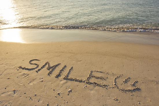 the-word-smile-written-in-the-sand-on-a-beach_u-l-pu6ubs0